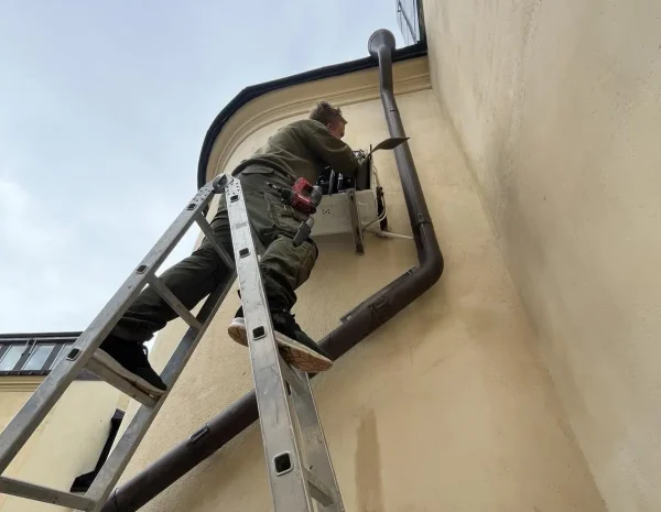 kille på stege som jobbar med luftvärmepump